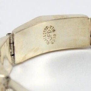 May include: Silver bracelet with a hinged clasp and a turquoise stone. The bracelet is stamped with "925 STERLING MEXICO" on the inside.