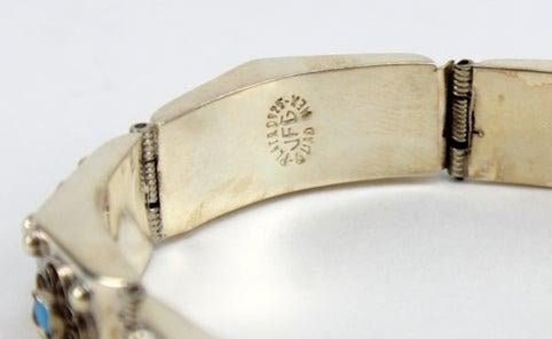 May include: Silver bracelet with a hinged clasp and a turquoise stone. The bracelet is stamped with "925 STERLING MEXICO" on the inside.