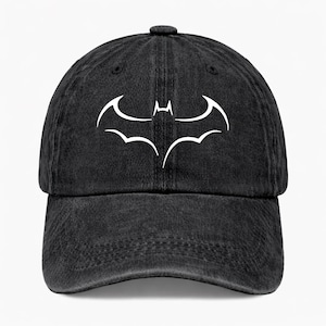 May include: A black baseball cap with a distressed, washed-out texture. The front panel features a white, stylized outline of a bat-shaped emblem centered on the crown. The cap has a curved brim, stitched eyelets, and a structured six-panel design.