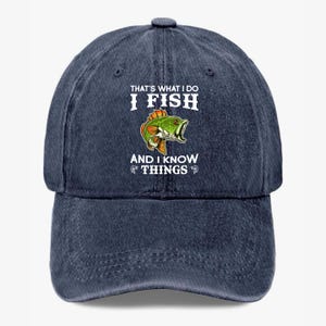 May include: A white ceramic mug with a black handle and the text "But First, Coffee" in a black, bold font. The mug is sitting on a wooden surface. The mug is approximately 4 inches tall.