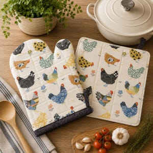 Puede incluir: Un guante de cocina acolchado y un agarrador cuadrado a juego con tela de color crema, estampados con un patrón repetitivo de gallinas en varios colores como azul, amarillo, negro y marrón, con un borde de tela gris oscuro en el guante.