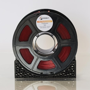 May include: A black spool of red translucent PLA Performance 3D printing filament. The spool is labeled "ORGELY" and includes the text "Translucent Red". The filament is held in a black honeycomb-patterned holder.