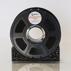May include: A black spool of ORGELY PLA Performance Translucent Teal filament for 3D printing. The spool is mounted on a black honeycomb-patterned stand. The label indicates a nozzle temperature range of 190-220°C and a bed temperature range of 50-65°C.