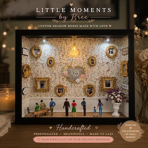 May include: A custom shadow box with miniature figures and framed photos. The box features a floral wallpaper background, small figures, and the text "LITTLE MOMENTS by Bree". The box is handcrafted and personalized.