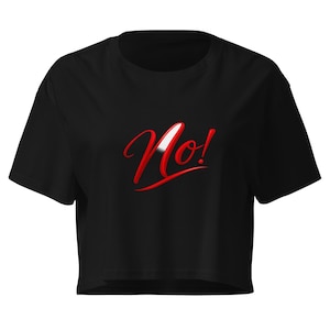 Può includere: Top corto nero con la scritta "No!" in rosso sul davanti. La parola ha un'evidenziazione bianca e il punto esclamativo è anch'esso rosso. La maglietta ha maniche corte e girocollo.