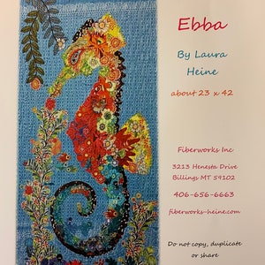 May include: A colorful, mosaic-style seahorse made of fabric scraps, with a blue background. The artwork is titled "Ebba" by Laura Heine and measures approximately 23 inches by 42 inches. Contact information for Fiberworks Inc. is included.