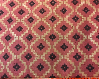 May include: Close-up of a fabric with a repeating geometric pattern. The design features diamond shapes in a dusty rose color, outlined with a tan hue, and accented with dark brown floral-like shapes. An orange ruler with "Made in U.S.A." is at the bottom.