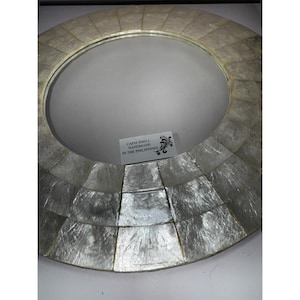 Puede incluir: Una taza de cerámica blanca con un asa negra y el texto "But First, Coffee" en negro y negrita. La taza está sobre una superficie de madera.