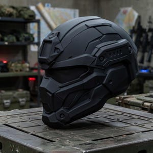 May include: A matte black tactical helmet featuring a full-face design with an integrated visor, a front-mounted accessory bracket, and segmented geometric paneling across the shell, providing a sleek, uniform appearance for protective gear.