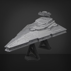 May include: A grey model of a Star Destroyer spaceship, with detailed features and a triangular form. The model is supported by a black stand, highlighting its design. The spaceship model is a collectible item.