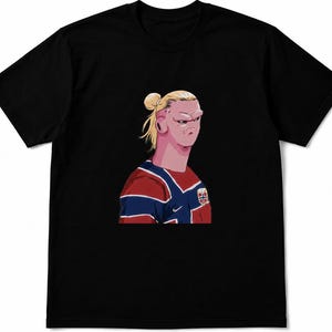 以下が含まれることがあります： お団子ヘアのブロンドの人物のグラフィックイラストが描かれた黒の半袖Tシャツ。人物は赤、白、青のジャージを着用しており、胸元にはノルウェー国旗のエンブレムがスタイライズされたアート形式で描かれています。