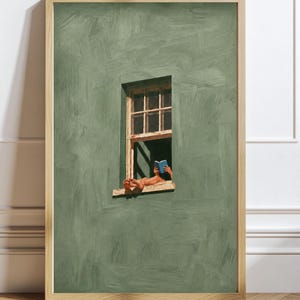 May include: A framed wall art print featuring a sage green textured wall with a single rectangular window. A person is reclining in the window frame, reading a small blue book with their bare feet resting on the exterior ledge of the window.