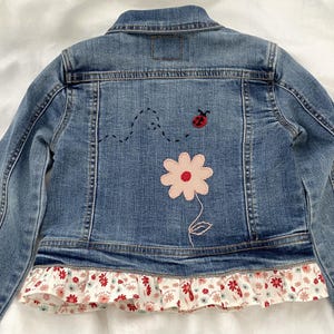 May include: A white ceramic mug with a black handle and the text "But First, Coffee" in a handwritten style. The mug is on a white surface. The mug is approximately 4 inches tall.