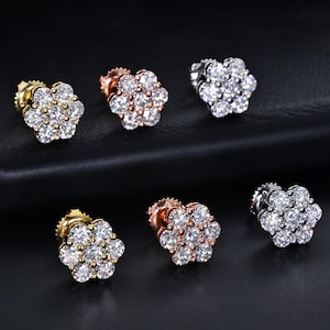 May include: Six stud earrings arranged in two rows, each featuring a cluster of seven round, clear, faceted stones set in a flower shape. The metal settings include yellow gold, rose gold, and silver tones, each with a secure post backing.