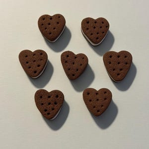 May include: A set of three ceramic mugs with a speckled, matte finish. The mugs are in shades of cream, light brown, and dark brown. Each mug has a simple, minimalist design, perfect for coffee or tea.