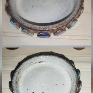 May include: A small, round, antique ceramic dish with a white interior and a decorative, scalloped rim. The rim is a mix of brown, blue, and turquoise accents. The dish has a rustic, aged appearance.