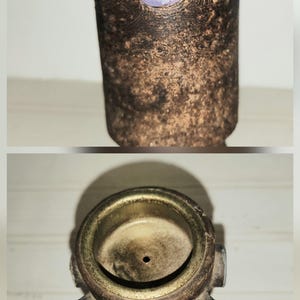 May include: A handcrafted, cylindrical ceramic vase with a textured, brown exterior. The vase is adorned with three colorful, circular accents: blue, purple, and turquoise. The top view reveals a circular opening and a small drainage hole.