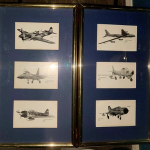 May include: Two framed sets of black and white illustrations of different airplanes. Each set has three illustrations. The frames are gold and have a blue background.