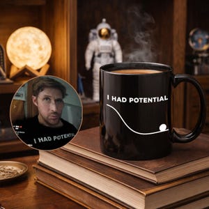 May include: A black coffee mug with the text "I HAD POTENTIAL" and a white graphic of a ball rolling down a hill. The mug is on a stack of books. A man wearing a shirt with the same text is in a circular inset.