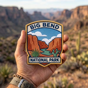 May include: Embroidered patch featuring a landscape scene from Big Bend National Park. The patch has a blue sky with white clouds, a river, and desert plants. The text "BIG BEND NATIONAL PARK" is displayed.