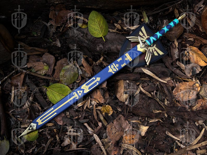 Pode incluir: Uma espada de fantasia azul e dourada com um escudo. A espada tem uma l&acirc;mina azul com detalhes dourados e uma guarda dourada. O escudo &eacute; preto com detalhes dourados e brancos. A espada e o escudo est&atilde;o sobre folhas e madeira.