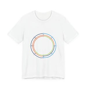 May include: White t-shirt featuring a circular graphic design with concentric rings in red, green, and blue. The design is centered on the front of the shirt. The shirt has short sleeves and a crew neck.