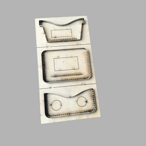 Op de afbeelding: Een houten stanssjabloon met drie verschillende vormen. De bovenste vorm is een gebogen container, de middelste is een rechthoek met afgeronde randen en de onderste heeft twee cirkels. De stansranden zijn van metaal.