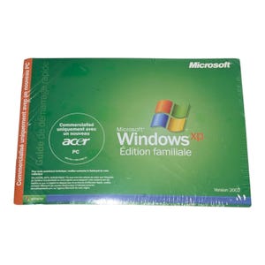 以下が含まれることがあります： 緑色の表紙の長方形のMicrosoft Windows XP Edition familialeソフトウェアマニュアル。表面にはWindowsロゴ、Microsoft Windows xpのテキスト、Acerのブランド名が記載されています。側面にはフランス語のテキストが書かれたオレンジ色の帯があります。