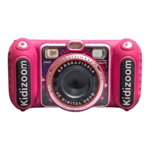 以下が含まれることがあります： 銀河模様のフロントパネルを備えたピンク色のVTech KidiZoom Duoデジタルカメラ。中央には5.0メガピクセル、4倍デジタルズームのレンズがあり、両側のグリップにはKidizoomという文字が黒色で縦に印刷されています。