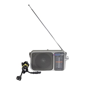 May include: A silver Panasonic portable radio with a black speaker grille, a long extendable metal antenna, and a black power cord with a two-pin plug. The front panel features a vertical analogue tuning dial with FM and AM frequency scales.