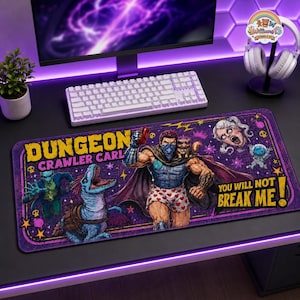 May include: A rectangular desk mat featuring a Dungeon Crawler Carl graphic with a muscular character in heart-patterned boxers, a blue dinosaur, and a small creature. The text reads Dungeon Crawler Carl and You Will Not Break Me.