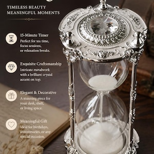 May include: A 15-minute hourglass featuring a silver-toned metal frame with intricate floral detailing and a clear glass bulb filled with white sand. The top of the frame is adorned with a large, faceted clear crystal accent piece.