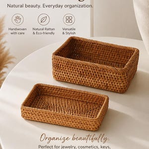May include: Two rectangular handwoven rattan storage boxes with an open top design. The text on the image reads: Handwoven Rattan Storage Box, Natural beauty. Everyday organization., Handwoven with care, Natural Rattan & Eco-friendly, Versatile & Stylish, Organize beautifully. Perfect for jewelry, cosmetics, keys, or little everyday essentials., Jewelry, Cosmetics, Keys, Decor.