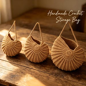 May include: Three handmade crochet storage bags in varying sizes, displayed on a wooden surface. The bags are a light brown colour, with a circular base and a handle. The text "Handmade Crochet Storage Bag" is visible in the image.