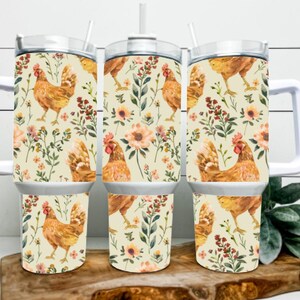 May include: Three stainless steel travel mugs with white handles and lids. The mugs feature a repeating pattern of watercolor chickens, flowers, and foliage on a cream background. Each mug has a straw.