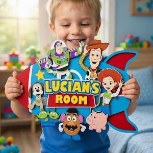 May include: A colorful, custom-made sign for a child's room, featuring characters from the Toy Story movie. The sign is shaped like a rocket with the text "LUCIAN'S ROOM" and includes images of Buzz Lightyear, Woody, and other characters.