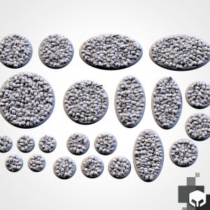 May include: A collection of various circular and oval-shaped miniature bases, each featuring a textured surface densely covered in a multitude of small, light gray sculpted skulls and skeletal remains, designed for tabletop gaming figures.