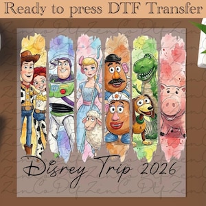 Peut inclure: Transfert DTF prêt à presser avec des illustrations à l'aquarelle des personnages de Toy Story. Le motif comprend Woody, Buzz l'Éclair, Bergère, M. Patate, Rex, Zigzag et Hamm. Le texte "Disney Trip 2026" est également inclus.