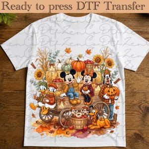 May include: A white t-shirt featuring a graphic of Mickey Mouse, Minnie Mouse, Donald Duck, Daisy Duck, Goofy, Pluto, Chip, and Dale on a wooden wagon filled with pumpkins, sunflowers, and apples, with the text Ready to press DTF Transfer.