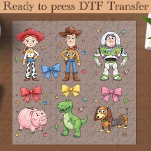 Peut inclure: Transfert DTF avec les personnages de dessins animés Jessie, Woody, Buzz Lightyear, un cochon rose, un dinosaure vert et un chien teckel. Le motif comprend des nœuds, des étoiles, des planètes et le texte "Ready to press DTF Transfer".