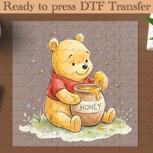 Pode incluir: Uma transferência DTF com um urso de desenho animado com uma camisa vermelha, segurando um pote de mel com a palavra "HONEY". O urso é cercado por abelhas e flores. O texto "Ready to press DTF Transfer" está no topo.