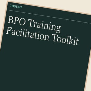 Könnte beinhalten: Ein Stapel Papiere mit einem dunkelblauen Umschlag, auf dem in weißer Schrift "BPO Training Facilitation Toolkit" steht. Das Wort "TOOLKIT" steht oben. Der Hintergrund ist dunkelgrün.