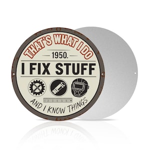 May include: A round metal sign with the text "THAT'S WHAT I DO - 1950. I FIX STUFF AND I KNOW THINGS." The sign has a distressed, vintage look with images of tools. A second, blank metal disc is visible.