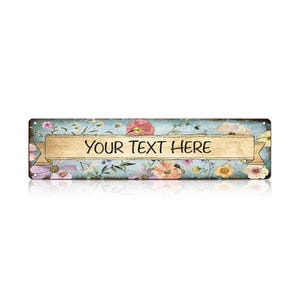 May include: Rectangular metal sign with a floral design and the text "YOUR TEXT HERE" on a banner. The sign has a distressed, vintage look with a light blue background and colorful flowers.