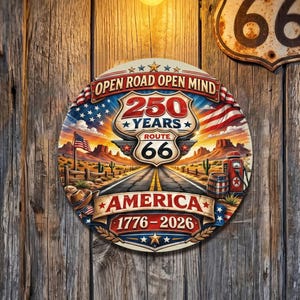 以下が含まれることがあります： 「Open Road Open Mind」と「250 Years Route 66 America 1776-2026」の文字が入った丸いルート66の看板。アメリカ国旗、砂漠の風景、ヴィンテージのガソリンスタンドが描かれています。
