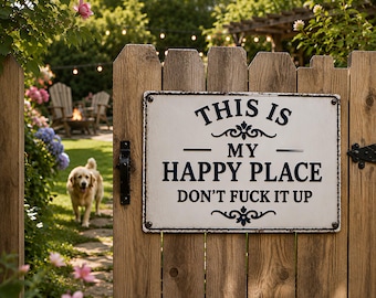 May include: A rectangular white metal sign with dark blue text that reads THIS IS MY HAPPY PLACE DON'T FUCK IT UP, featuring decorative scrollwork accents above and below the text, mounted on a vertical wooden fence gate with black hardware.