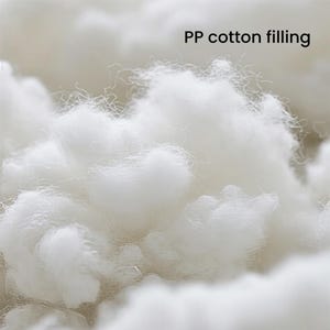 Pu&ograve; includere: Una vista ravvicinata di materiale di imbottitura in cotone PP bianco e soffice. Le fibre sono morbide, ariose e voluminose, creando una consistenza simile a una nuvola. Il testo "PP cotton filling" &egrave; visibile nell'angolo in alto a destra.