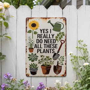 Puede incluir: Un letrero metálico rectangular con un borde oxidado sobre un fondo blanco. Presenta un girasol amarillo, una regadera verde, dos suculentas en macetas, una planta en maceta y una pala de jardín. El texto dice: YES I REALLY DO NEED ALL THESE PLANTS.