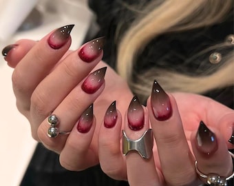 Uñas postizas estilo stiletto con efecto degradado cereza oscuro, hechas a mano, con detalles cromados góticos.