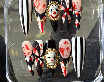 Uñas postizas hechas a mano con diseño de payaso sangriento, estilo gótico de terror, con detalles dorados en 3D.